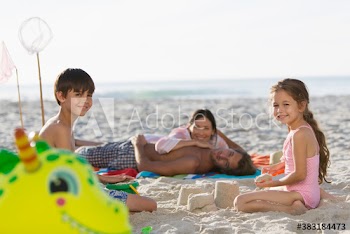 Portrait happy family relaxing and making sandcastle on sunny beach