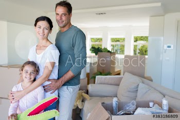 Portrait happy family unpacking boxes in new house