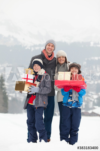 Portrait happy family with Christmas gifts in snowy field