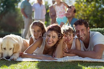 Portrait happy family with dog relaxing on blanket