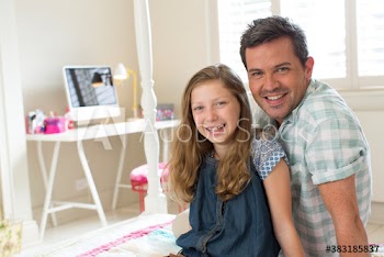 Portrait happy father and daughter in bedroom