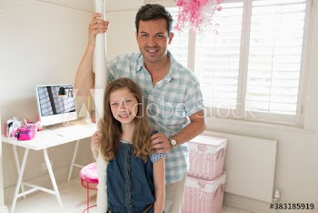 Portrait happy father and daughter in bedroom