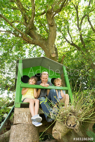 Portrait happy father and kids in treehouse