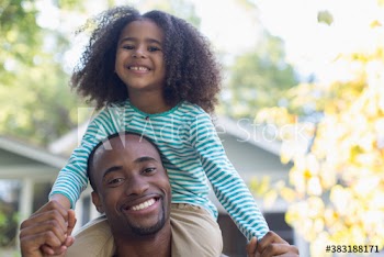 Portrait happy father carrying daughter on shoulders