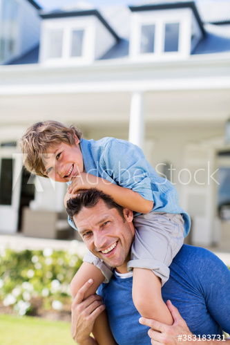 Portrait happy father carrying son on shoulders