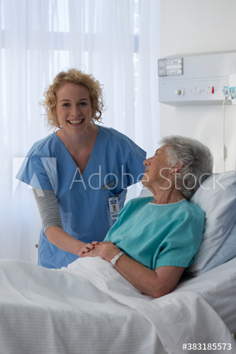 Portrait happy female nurse caring for senior patient in hospital room