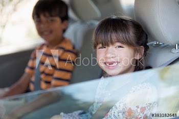 Portrait happy gap toothed girl riding in backseat of car