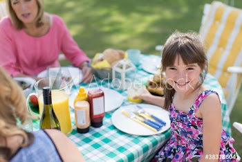 Portrait happy girl enjoying patio lunch with family
