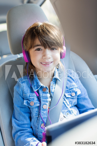 Portrait happy girl with headphones and digital tablet in car