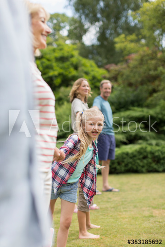 Portrait happy girl with multi-generation family in backyard