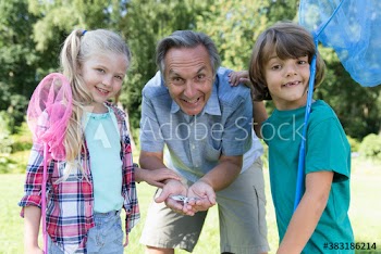 Portrait happy grandfather and grandkids catching butterflies