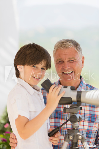Portrait happy grandfather and grandson using telescope