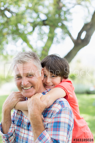Portrait happy grandfather piggybacking grandson