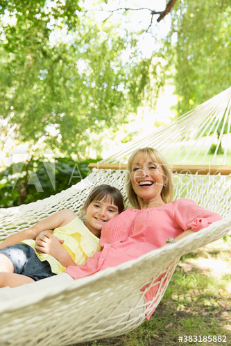 Portrait happy grandmother and granddaughter relaxing in hammock