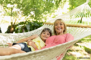 Portrait happy grandmother and granddaughter relaxing in hammock