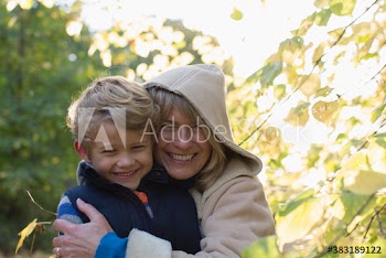 Portrait happy grandmother and grandson hugging in park