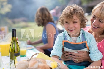 Portrait happy grandson with grandmother enjoying lunch at table
