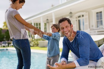 Portrait happy man at poolside with family