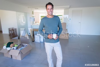 Portrait happy man with coffee moving into new house