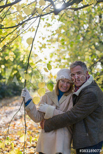 Portrait happy mature couple in autumn park