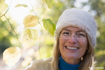 Portrait happy mature woman wearing fur hat in park