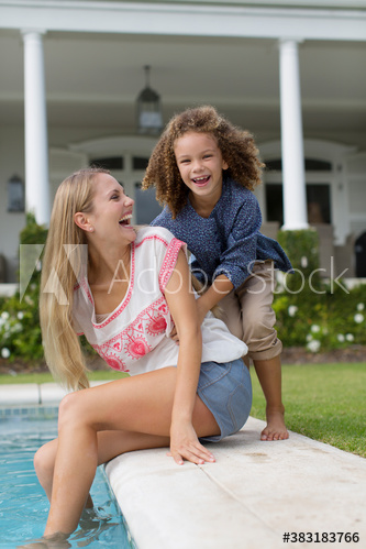 Portrait happy mother and daughter at poolside