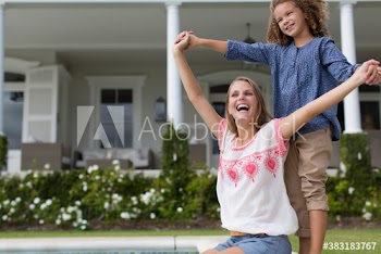 Portrait happy mother and daughter holding hands at poolside