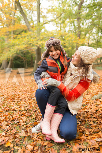 Portrait happy mother and daughter in autumn woods