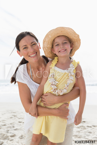 Portrait happy mother and daughter on sunny beach