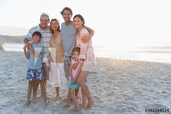 Portrait happy multi-generation family on sunny beach