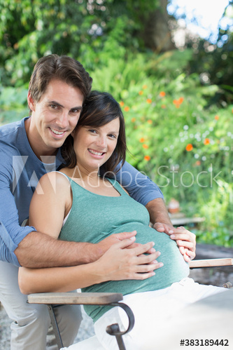Portrait happy pregnant couple on patio