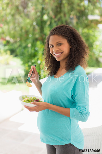 Portrait happy pregnant woman eating healthy salad