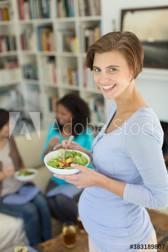 Portrait happy pregnant woman eating salad