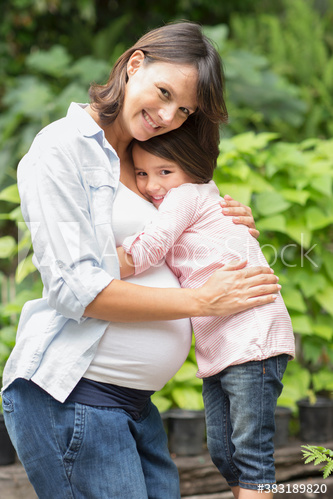 Portrait happy pregnant woman hugging daughter