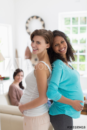 Portrait happy pregnant women standing back to back