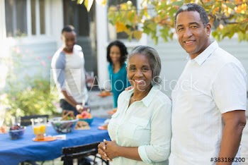 Portrait happy senior couple enjoying patio lunch with family