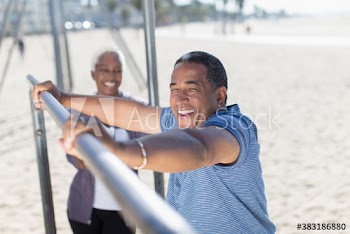 Portrait happy senior couple exercising on sunny beach