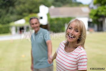 Portrait happy senior couple holding hands in backyard