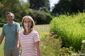 Portrait happy senior couple holding hands in sunny garden