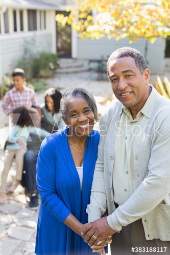 Portrait happy senior couple holding hands on patio