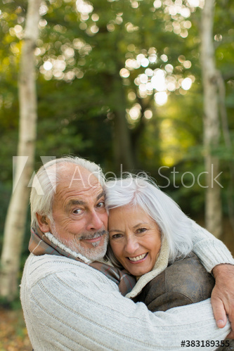 Portrait happy senior couple hugging in park