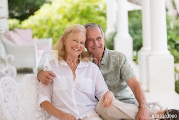 Portrait happy senior couple hugging on patio