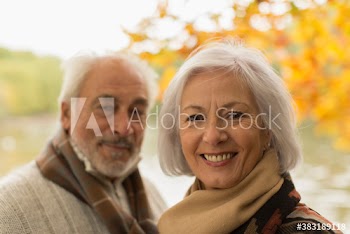 Portrait happy senior couple in autumn park