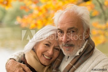Portrait happy senior couple in autumn park