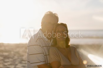 Portrait happy senior couple on sunny beach
