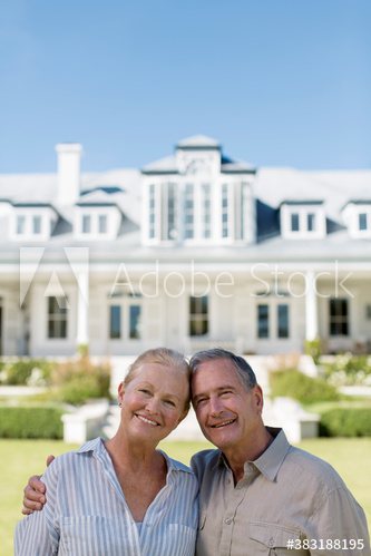 Portrait happy senior couple outside luxury house