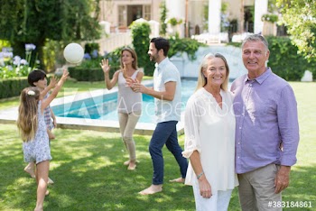 Portrait happy senior couple with family in backyard
