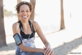 Portrait happy senior female runner with armband and headphones
