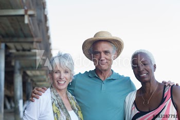 Portrait happy senior friends at beach