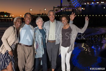Portrait happy senior friends dancing on beach at night